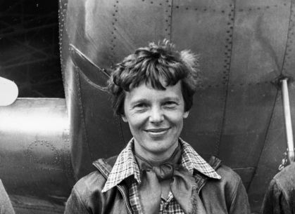 pilota Amelia Earhart em frente ao seu avião em uma foto preto e branca