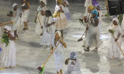 mulheres com vassouras na sapucai vestem roupas típicas de rituais afrobrasileiros