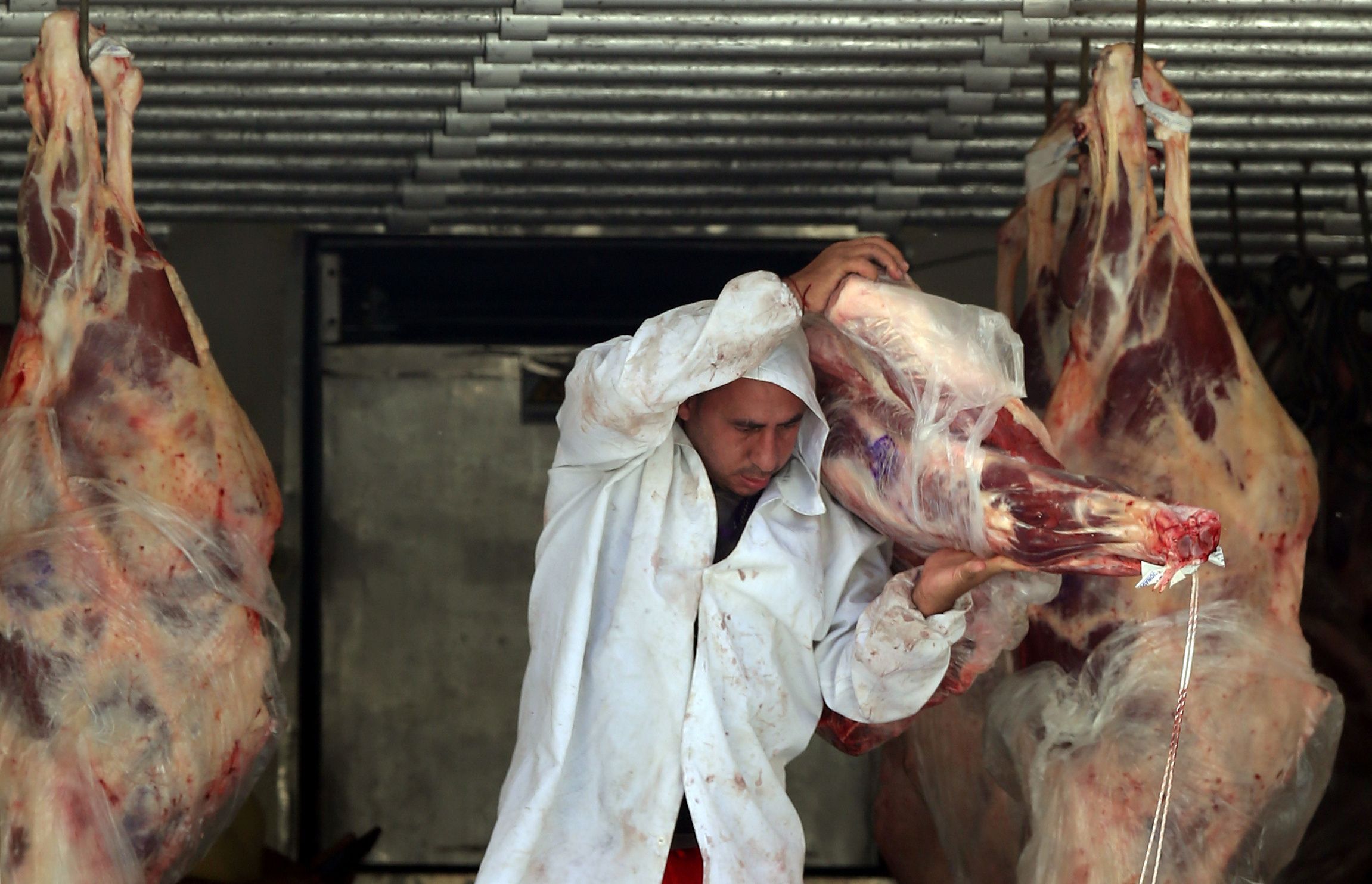 Açougueiro descarrega carne de um caminhão do lado de fora de um açougue em São Paulo, Brasil