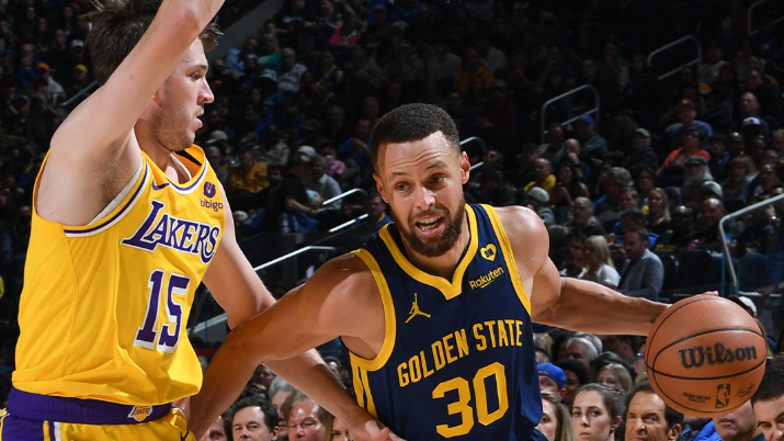 Stephen Curry tenta driblar Austin Reaves