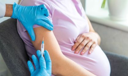 Mulher grávida recebe vacina em seu braço