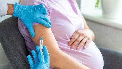 Mulher grávida recebe vacina em seu braço