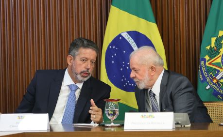 Arthur Lira, inclinado para a esquerda, conversa com Luiz Inácio Lula da Silva