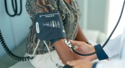 Médica medindo a pressão arterial de uma paciente