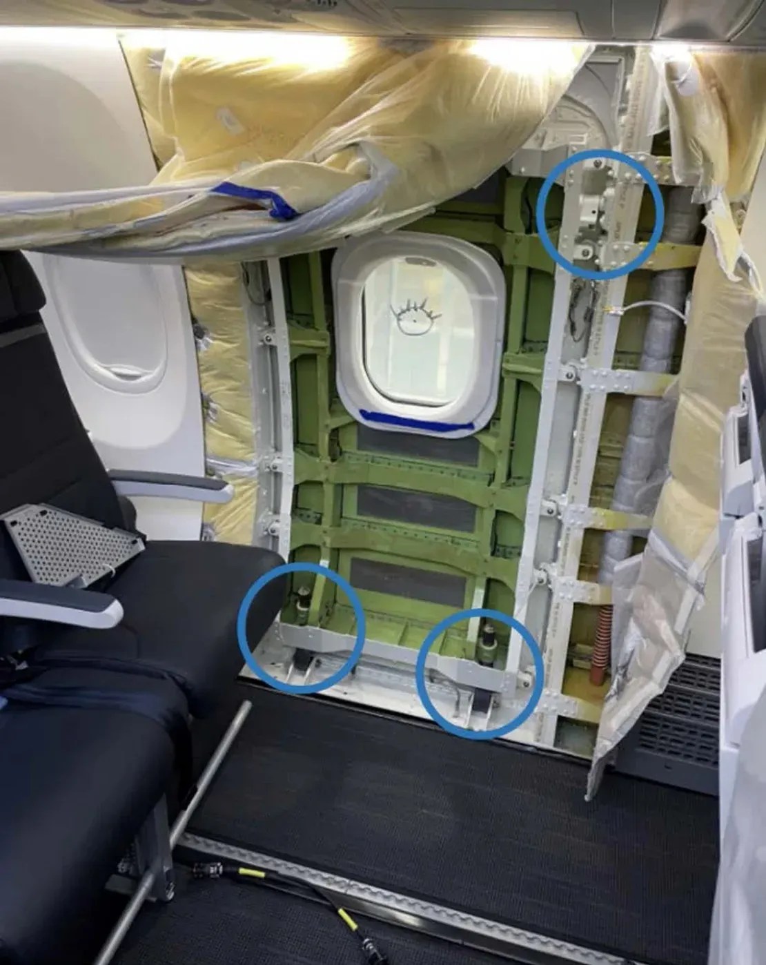 Foto mostra o plugue MED esquerdo imediatamente antes da restauração interna. Círculos mostram os três locais sem os parafusos de retenção, dois parafusos supressores de movimento vertical e o parafuso da guia superior dianteira. A pista guia superior traseira é coberta com isolamento e não pode ser vista na foto / Reprodução: NTSB/Boeing
