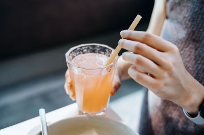 Mulher segurando um copo de suco de frutas
