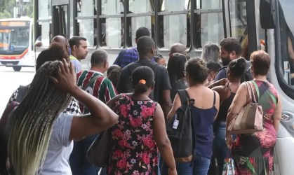 Pessoas enfileiradas para entrar no transporte público