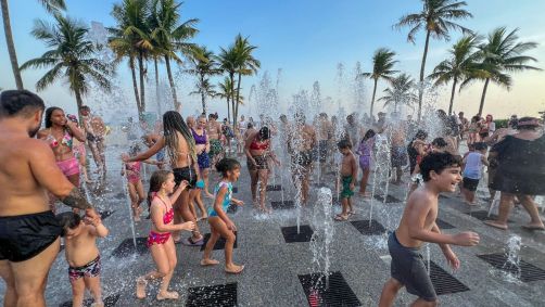 Banhistas se refrescam durante dia de forte calor em Praia Grande, litoral paulista