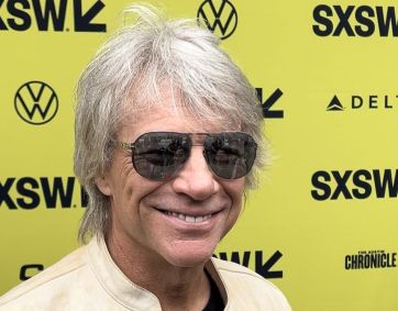 O cantor bon jovi posando para foto no backdrop do sxsw