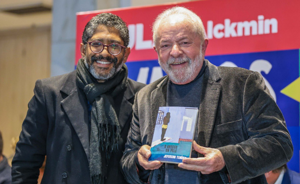 O autor Jeferson Tenório e o então candidato a presidente Lula (PT), que segura o livro "O Avesso da Pele", feito pelo escritor