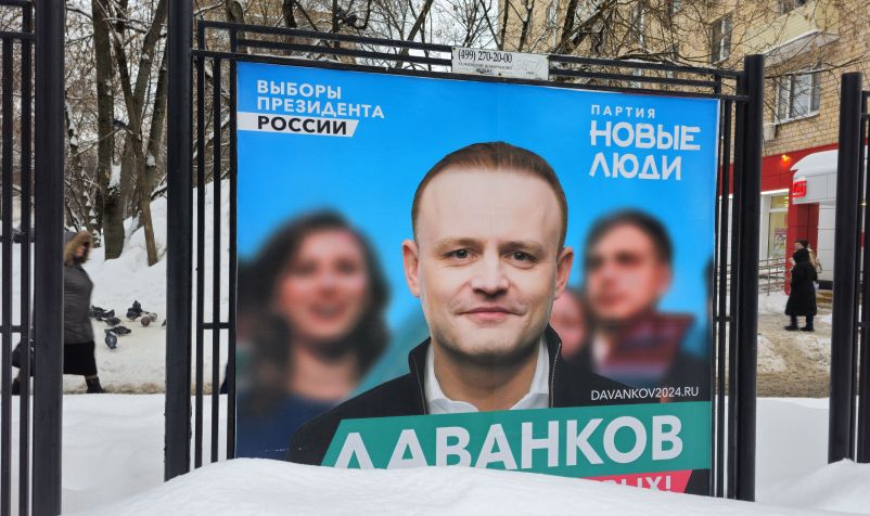 Pessoas passam por imagem de campanha de Vladislav Davankov, candidato nas eleições presidenciais pelo partido Novo Povo. Foto em Moscou, Rússia, 18 de fevereiro de 2024. / Contributor/Getty Images