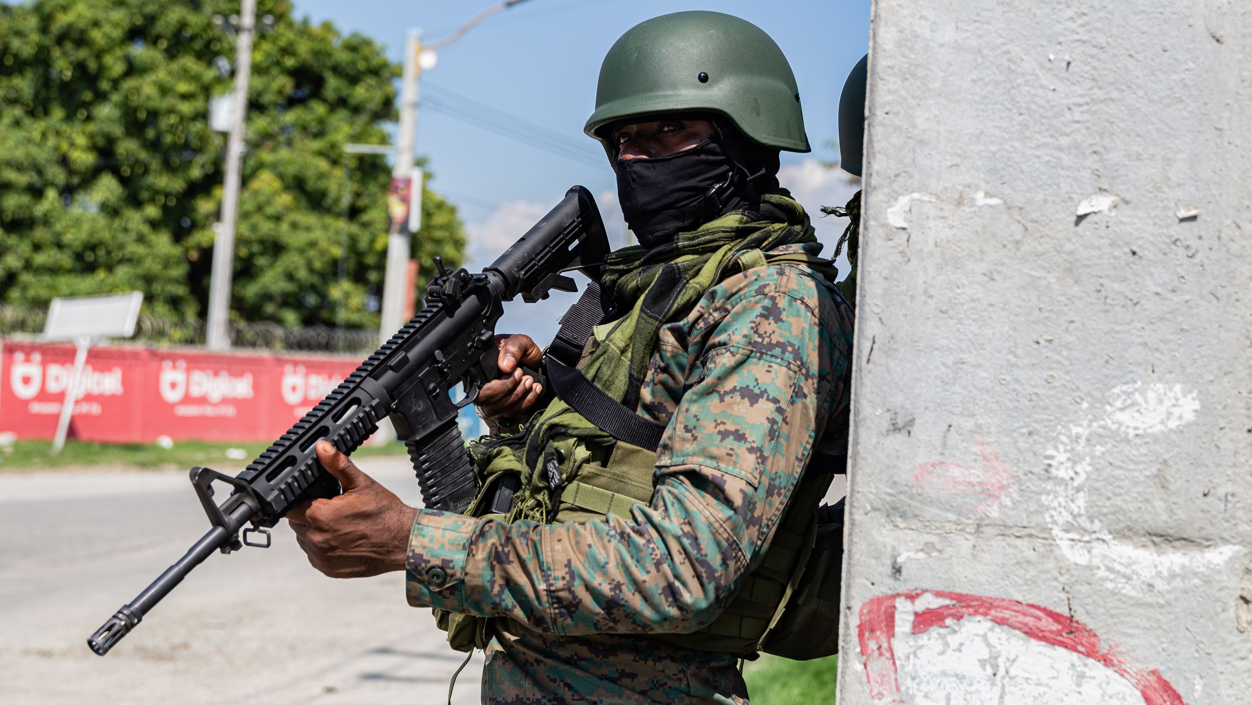Soldados haitianos posicionados atrás de um poste guardam a entrada do aeroporto internacional de Porto Príncipe depois que membros de gangues armadas trocaram tiros com policiais e soldados ao redor do local, 06 de março de 2024
