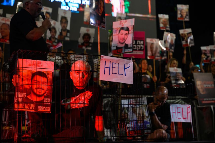Famílias de reféns sentam-se dentro de jaulas pedindo o retorno dos reféns, durante protesto em 30 de março de 2024 em Tel Aviv / Alexi Rosenfeld/Getty Images