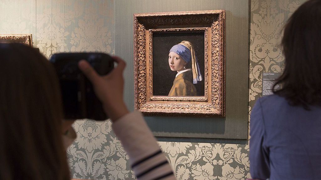 Jornalista tira uma foto do quadro 'Garota com brinco de pérola' de Johannes Vermeer na Sala Vermeer do Museu Mauritshuis em 20 de junho de 2014 em Haia, Holanda