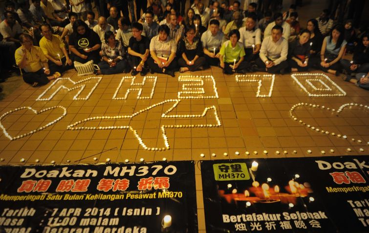Malaios se reúnem em vigília à luz de velas marcando um mês do desaparecimento do voo MH370 da Malaysia Airlines, em 8 de abril de 2014, em Kuala Lumpur. / Firdaus Latif/NurPhoto/Corbis via Getty Images