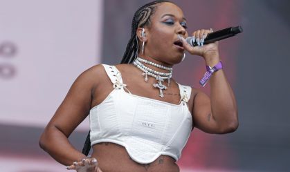 cantora no palco com um microfone na mão