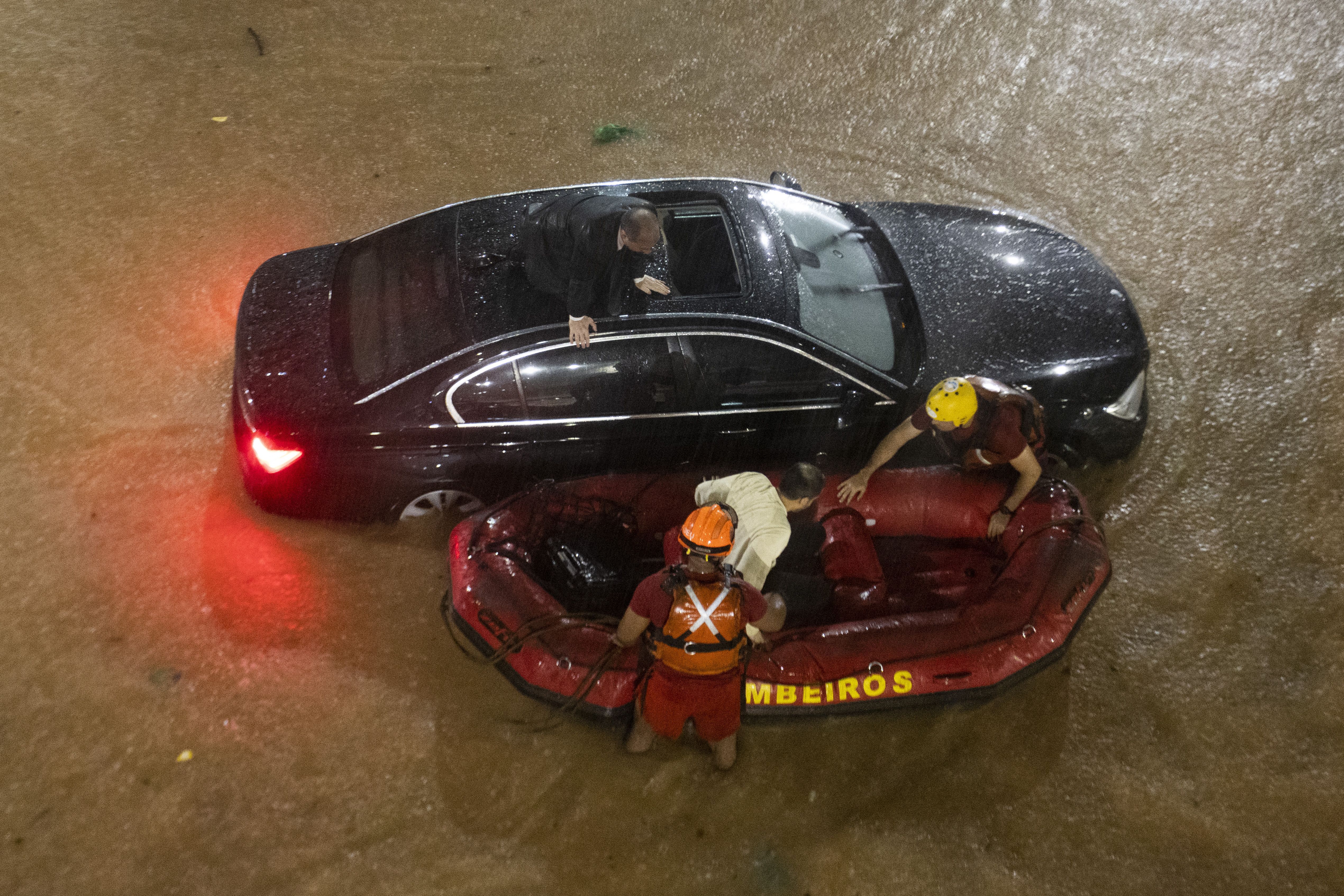 Passageiros de veículo de luxo são resgatados de barco pelos bombeiros após enchente na região central da capital paulista