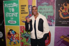 Thiago Oliveira faz símbolo de &quot;rock and roll&quot; e mostra a língua olhando para a câmera com jaqueta branca e preta