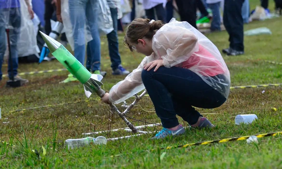 menina durante uma competição de astronomia com uma espécie de foguete