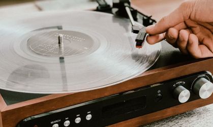 Pessoa ajusta agulha de vitrola para tocar disco de vinil