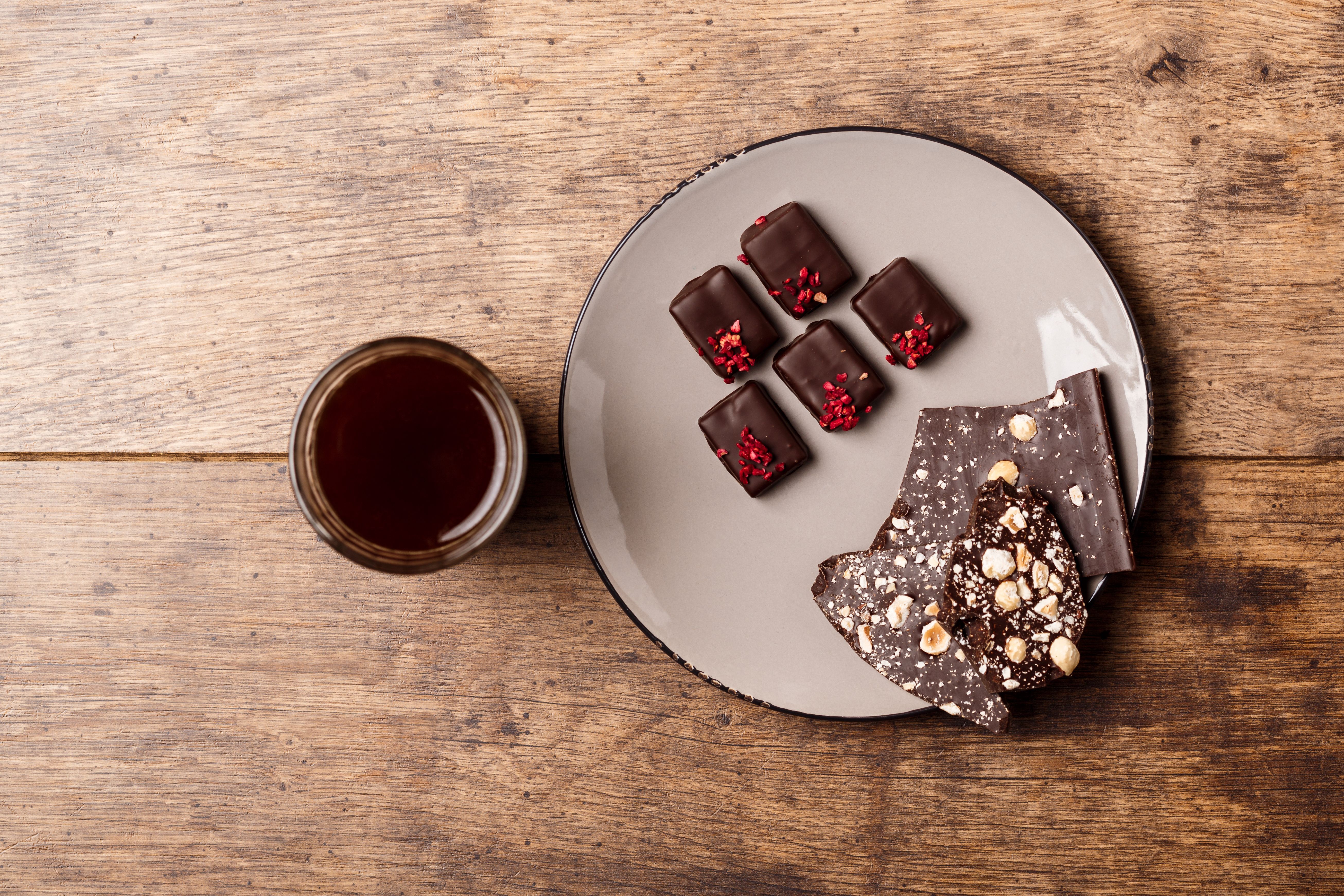 Chocolate candies and coffee over wooden background. Above.