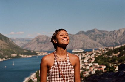 Mulher sorrindo em frente a uma paisagem