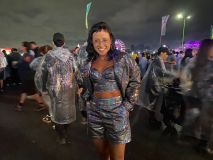 Mulher com mãos no bolso e roupa composta por blusa curta, shorts e blazer