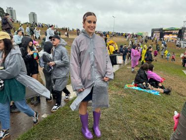 Mulher de capa de chuva cinza segurando do vento