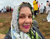 Senhora com pano na cabeça sorrindo e mostrando maquiagem