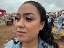 Jovem mostra maquiagem com delineado inferior rosa e pedrinhas na parte de cima