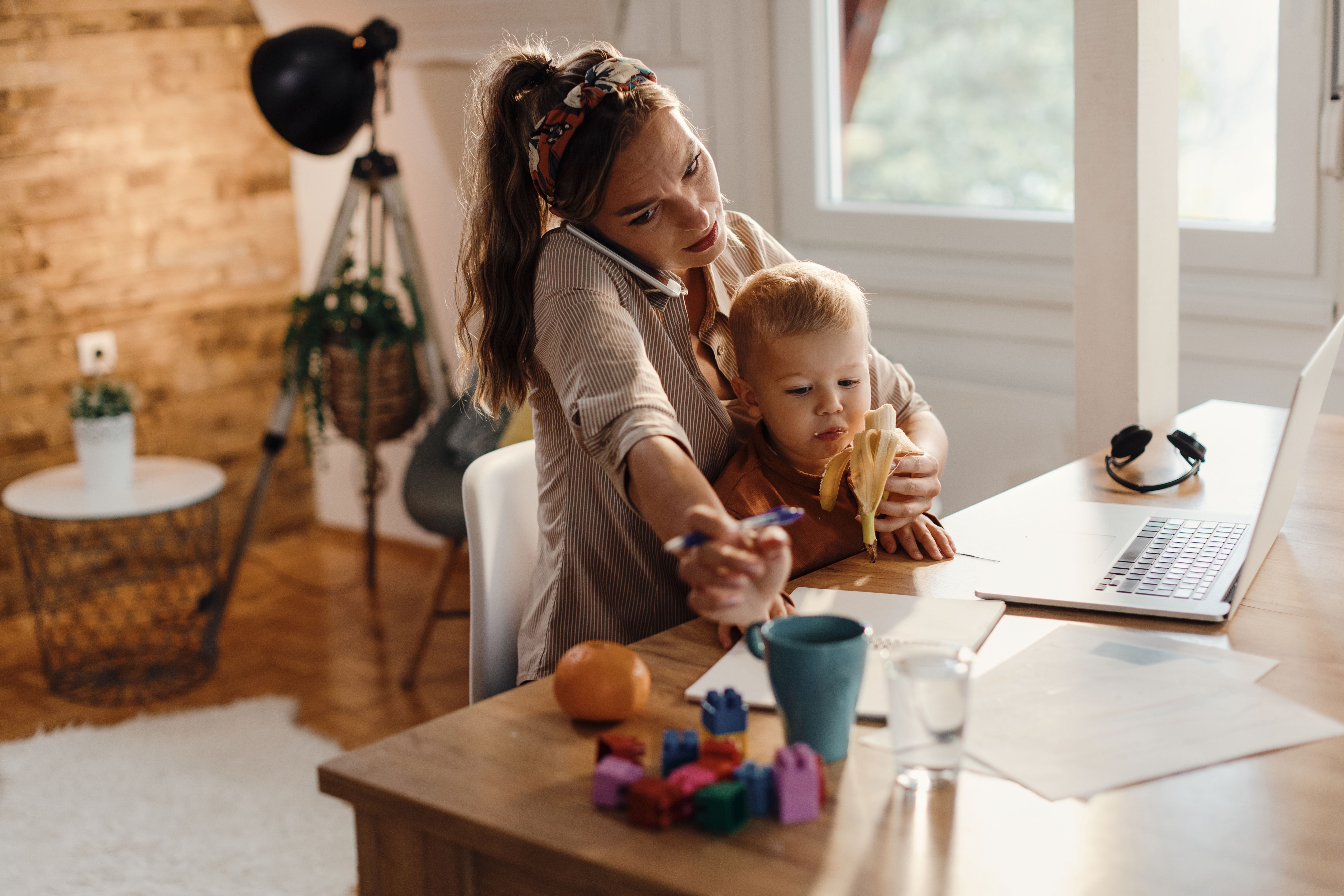 Multi-tasking mother taking care of her small son while working