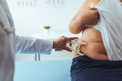 Médico usa um dispositivo para medir gordura abdominal de uma criança