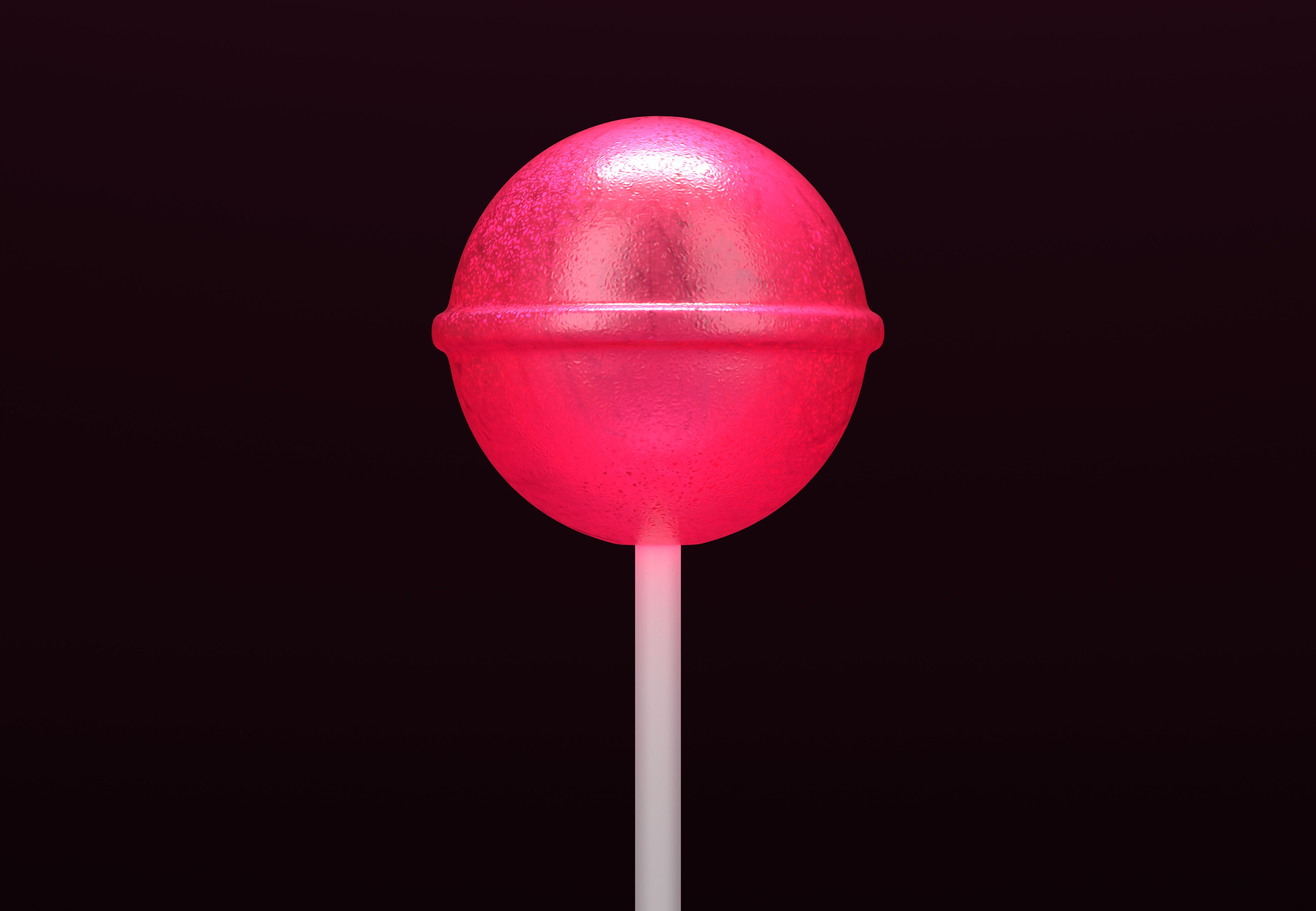 Pink lollipop on stick on black background