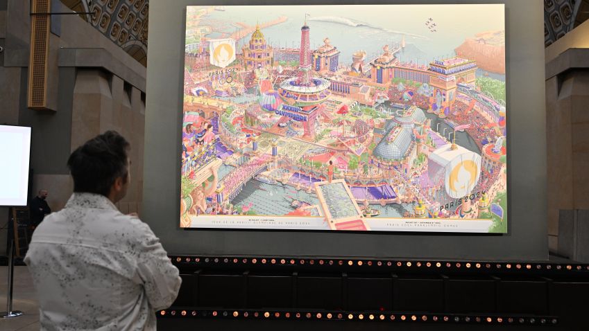 Ilustrador responsável pela obra, Ugo Gattoni observa os pôsteres de Paris 2024 / Mustafa Yalcin/Anadolu via Getty Images