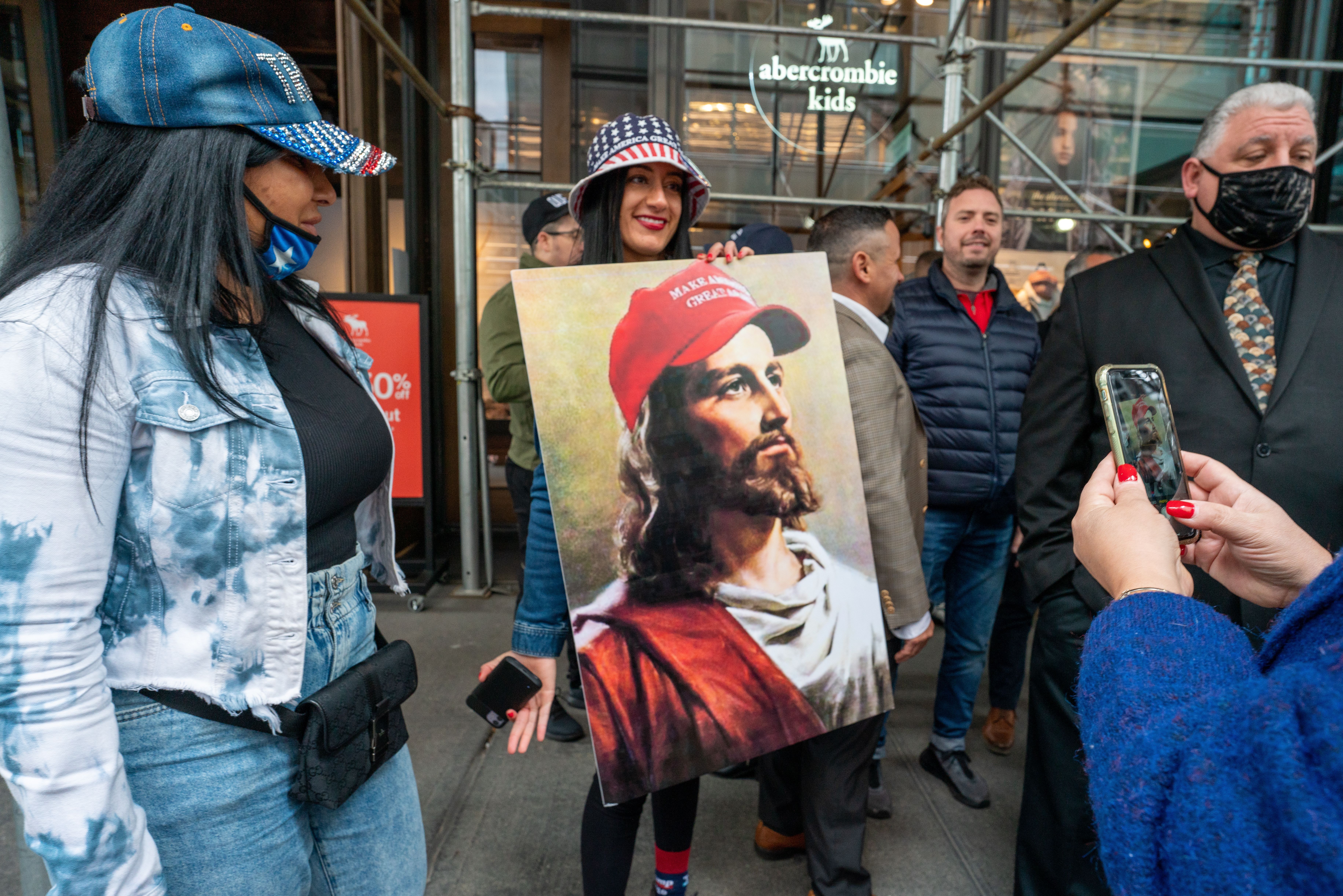 Pessoa segura uma pintura de Jesus usando um boné "Make America Great Again", em Nova York. / David Dee Delgado/Getty Images