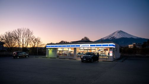 Vista ao entardecer no estacionamento da loja de conveniência Lawson com o Monte Fuji ao fundo durante o crepúsculo no Japão