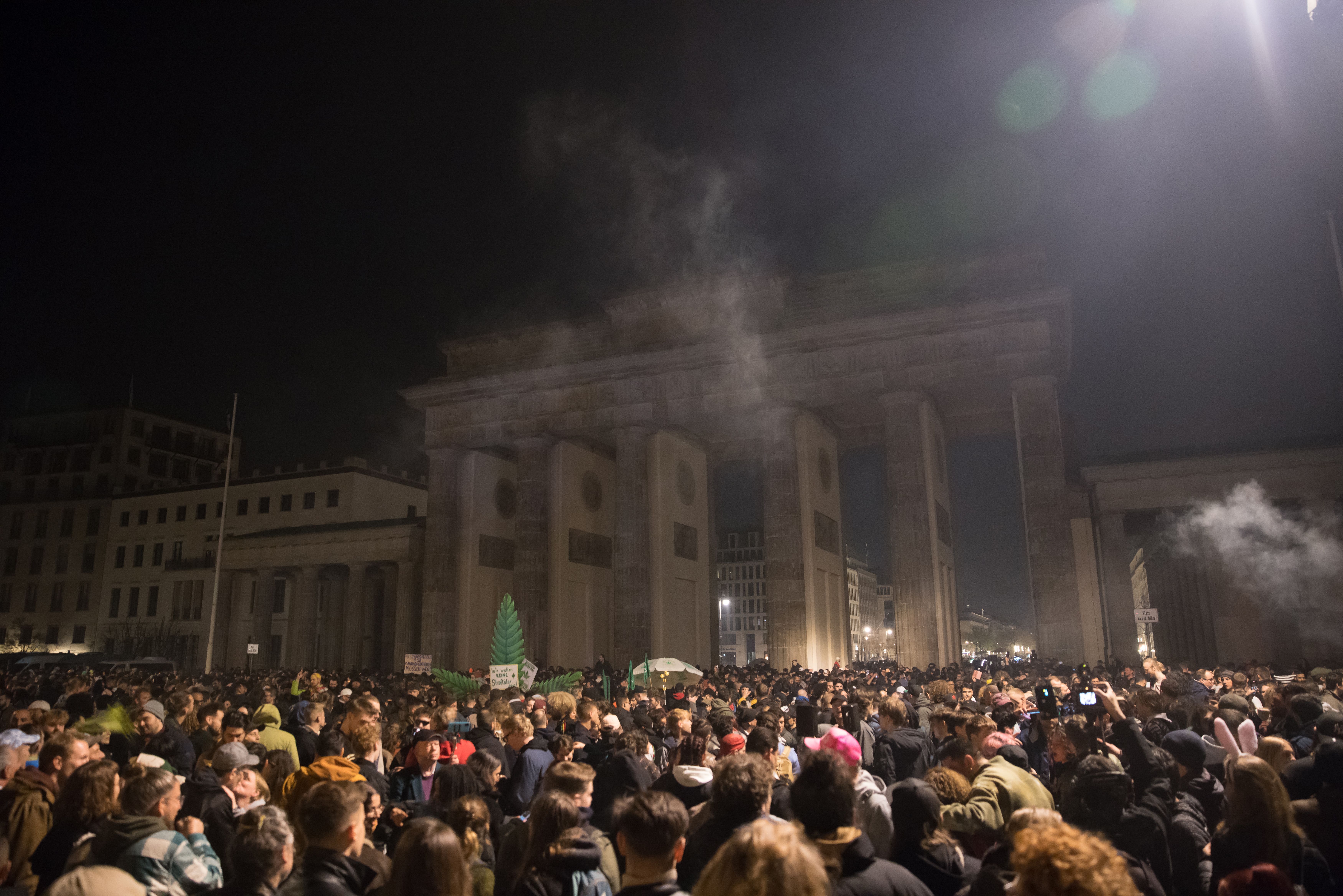 Entusiastas da cannabis fumam baseados legalmente no Portão de Brandemburgo, em Berlim, pouco após a meia-noite de 1º de abril de 2024, quando entrou em vigor a legalização parcial da maconha na Alemanha. / Michele Tantussi/Getty Images