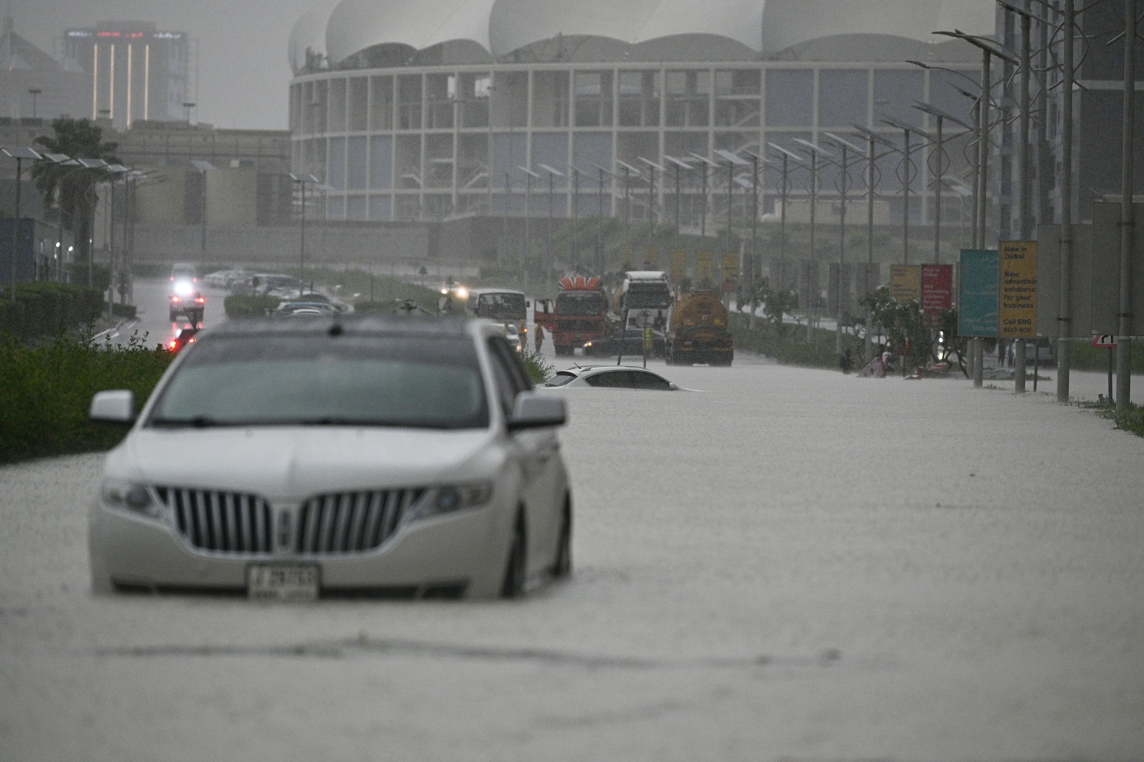 Carros atravessam estradas inundadas devido a fortes chuvas, já que as condições climáticas adversas afetam negativamente a vida diária em Dubai, Emirados Árabes Unidos, em 15 de abril de 2024. / Stringer/Anadolu via Getty Images