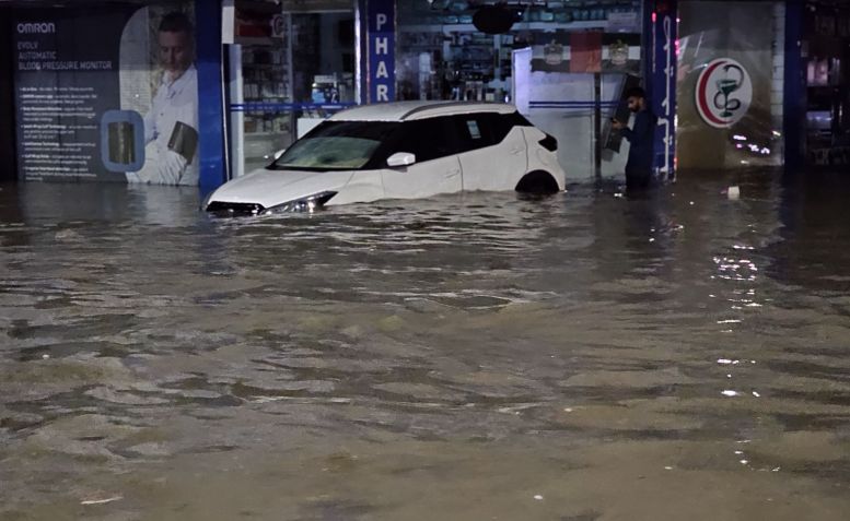 Carros atravessam estradas inundadas devido a fortes chuvas, já que as condições climáticas adversas afetam negativamente a vida diária em Dubai, Emirados Árabes Unidos, em 15 de abril de 2024 / Stringer/Anadolu via Getty Images
