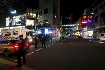 A polícia de NSW e funcionários do shopping center são vistos fora de Westfield Bondi Junction em 13 de abril de 2024 em Bondi Junction, no subúrbio de Sydney, Austrália.