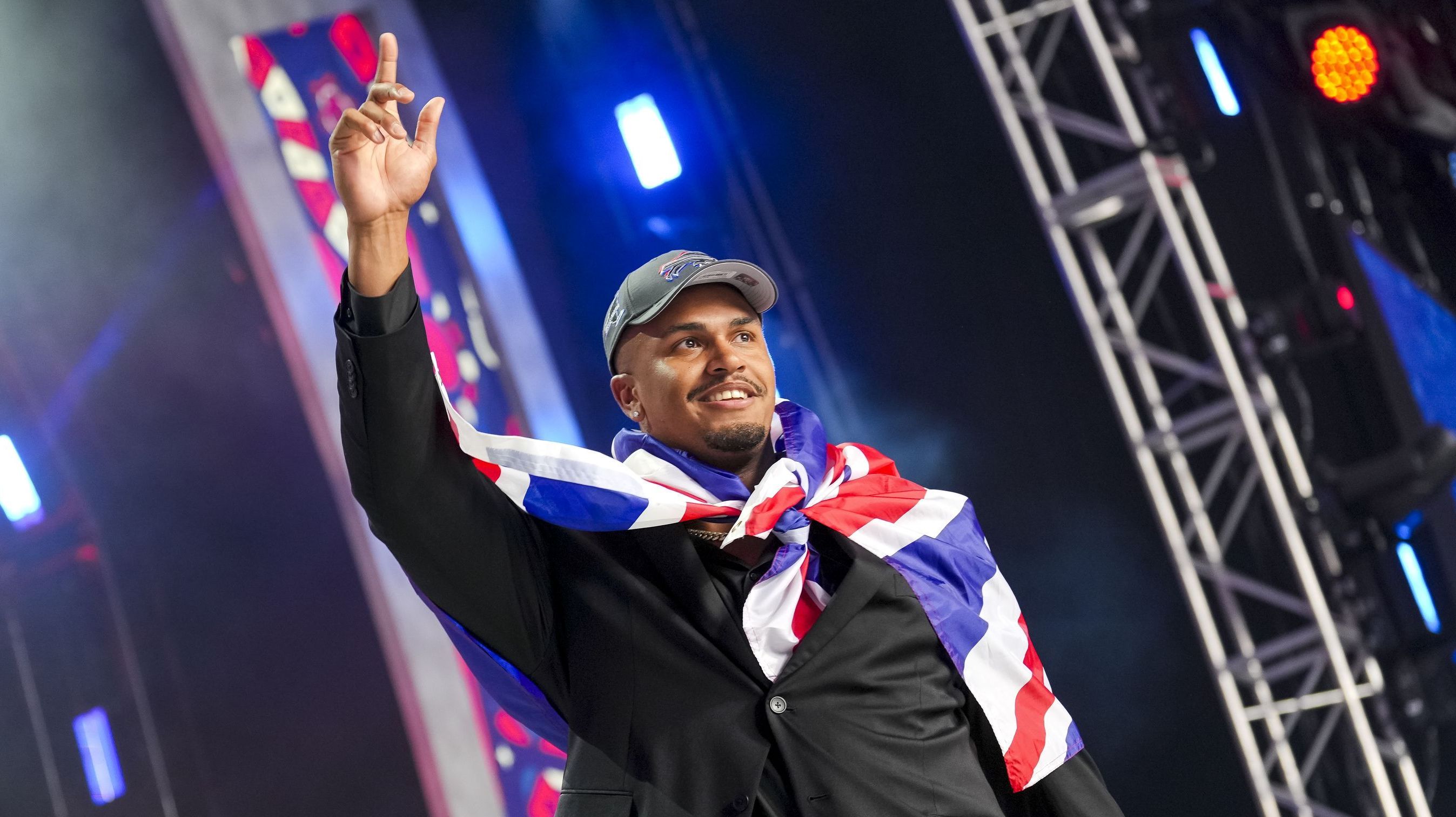 Travis Clayton acena para o público durante o draft da NFL