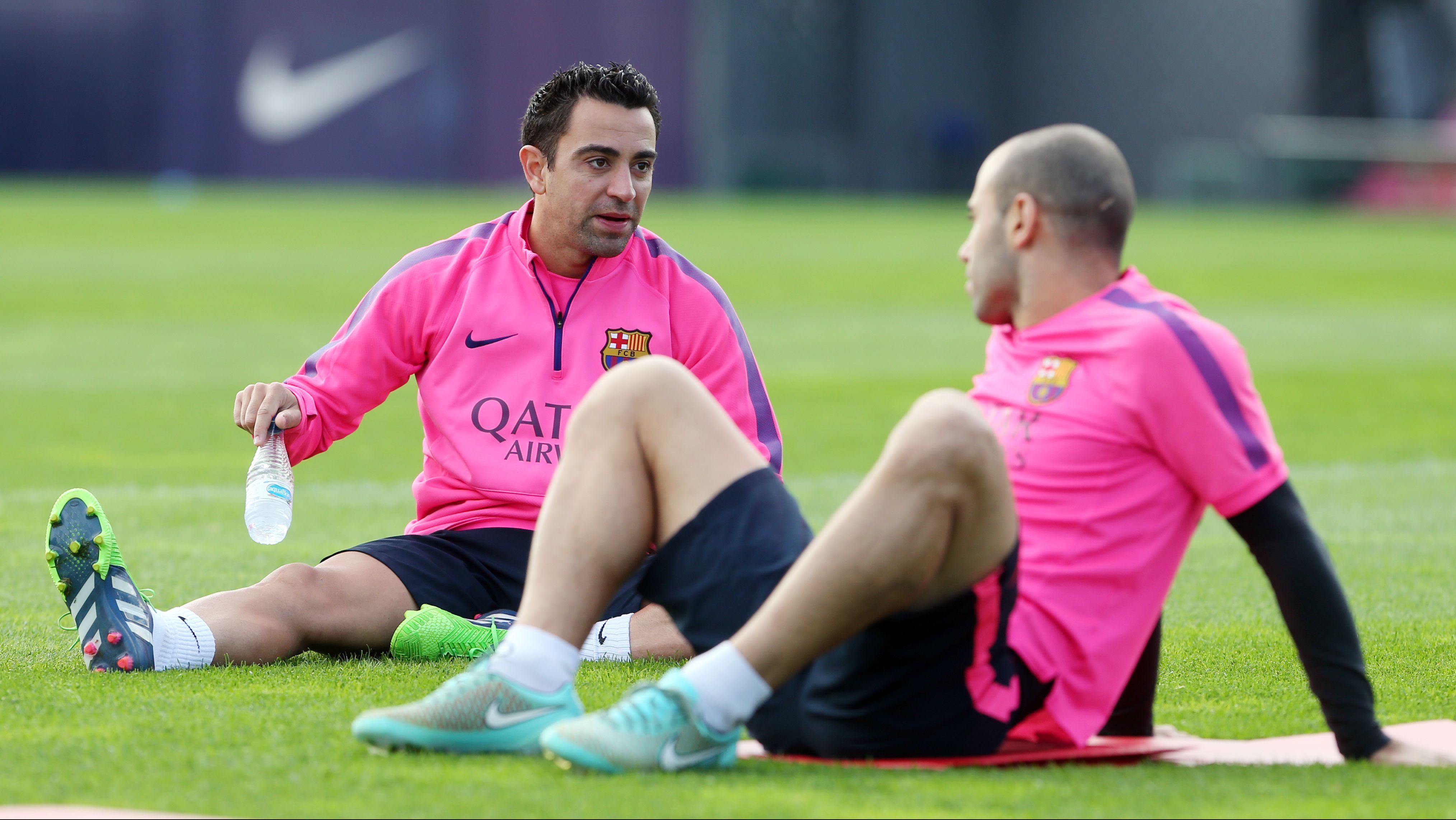 Xavi e Mascherano conversam durante treino do Barcelona em 2014 / Miguel Ruiz/FC Barcelona via Getty Images