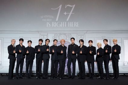 Na foto, os treze integrantes do grupo de k-pop posam um do lado do outro.