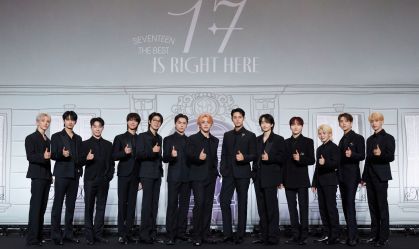 Na foto, os treze integrantes do grupo de k-pop posam um do lado do outro.