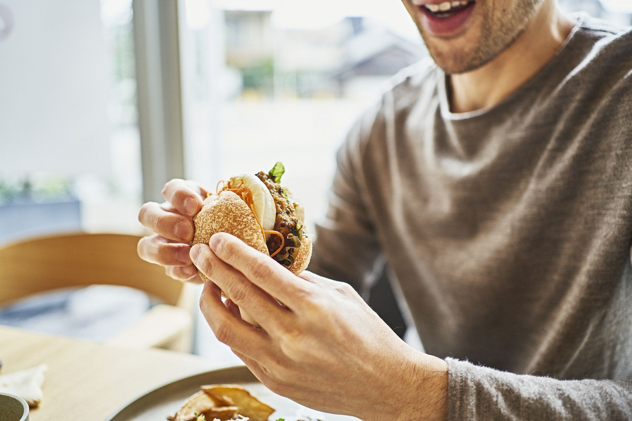 Homem comendo hamburguer