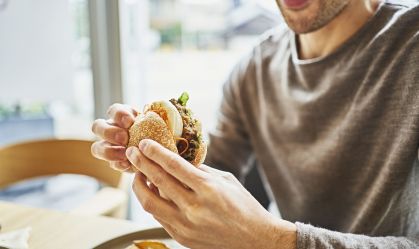 Homem comendo hamburguer