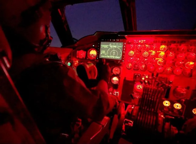 O capitão Sabin “Jett” Park pilota o B-52 à noite, usando iluminação vermelha da cabine para proteger sua visão no escuro. A tela principal é uma das poucas adições modernas ao cockpit / Oren Liebermann/CNN