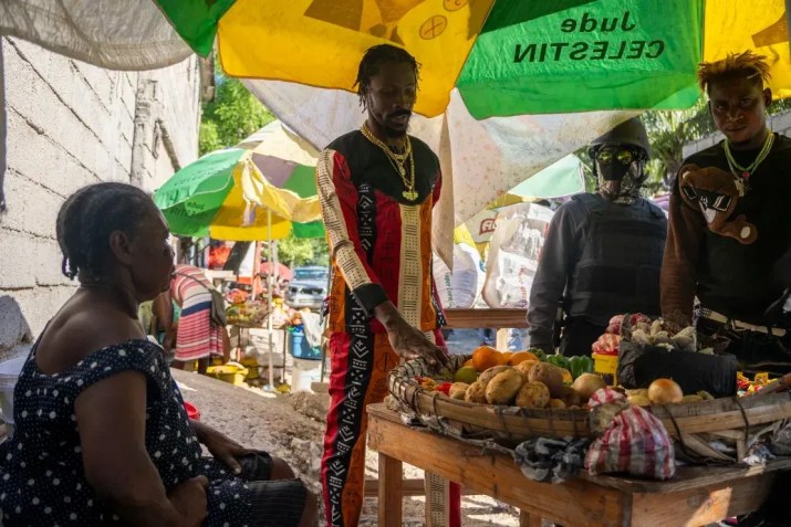 Um vendedor ambulante que mora no território da gangue Kraze Baryé, é abordado por Innocent, em Porto Príncipe, Haiti, em 18 de abril de 2024 / Evelio Contreras/CNN