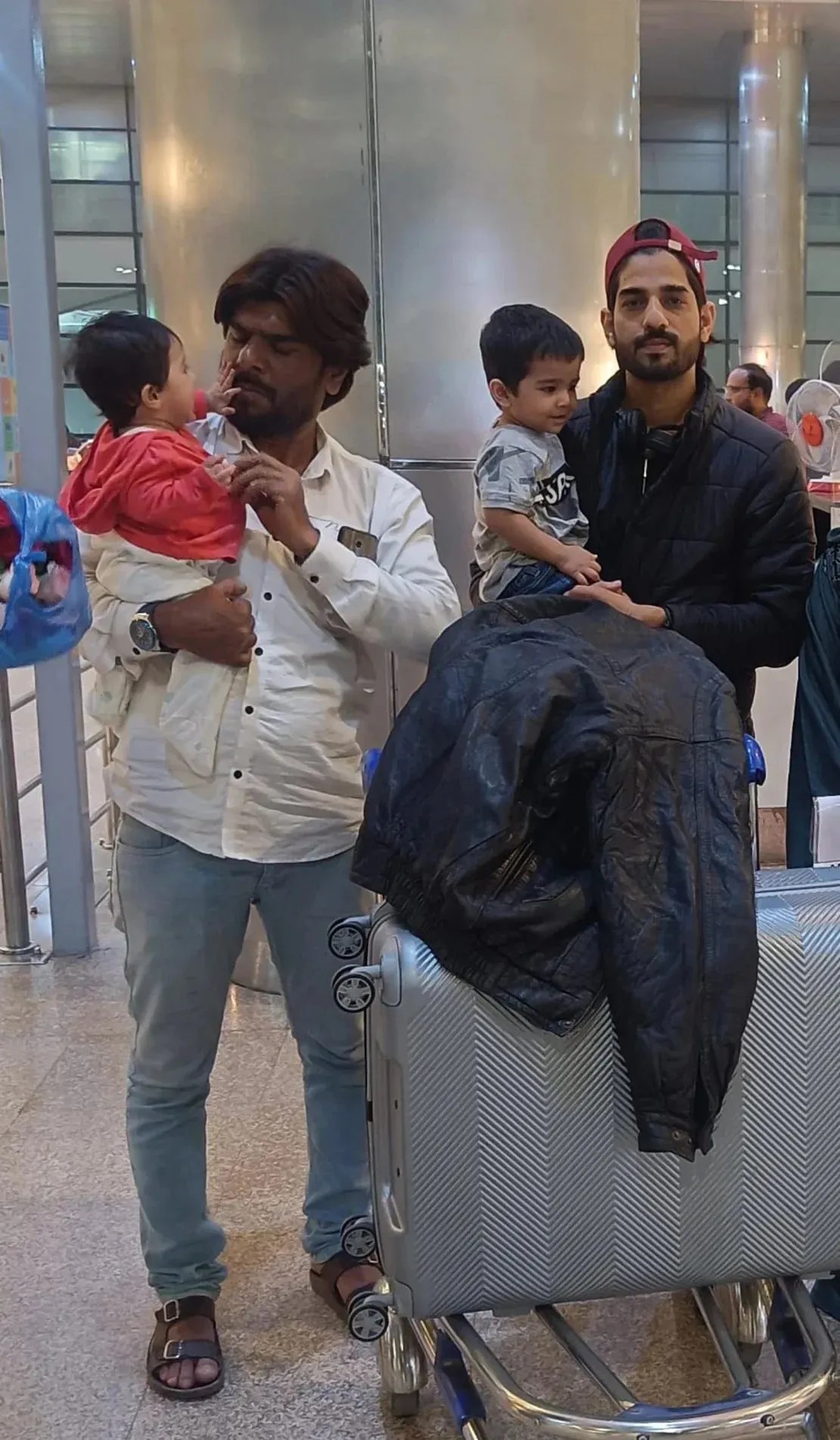 Asfran Mohammed, à direita, e seu irmão Imran são fotografados com os filhos de Asran antes de Asfran partir para a Rússia / Maomé Imran