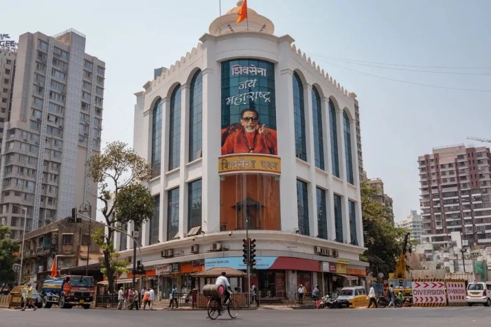 Um homem pedala por uma rua em frente à sede do Shiv Sena em Mumbai, Índia, em 16 de abril de 2024 / Noemi Cassanelli/CNN